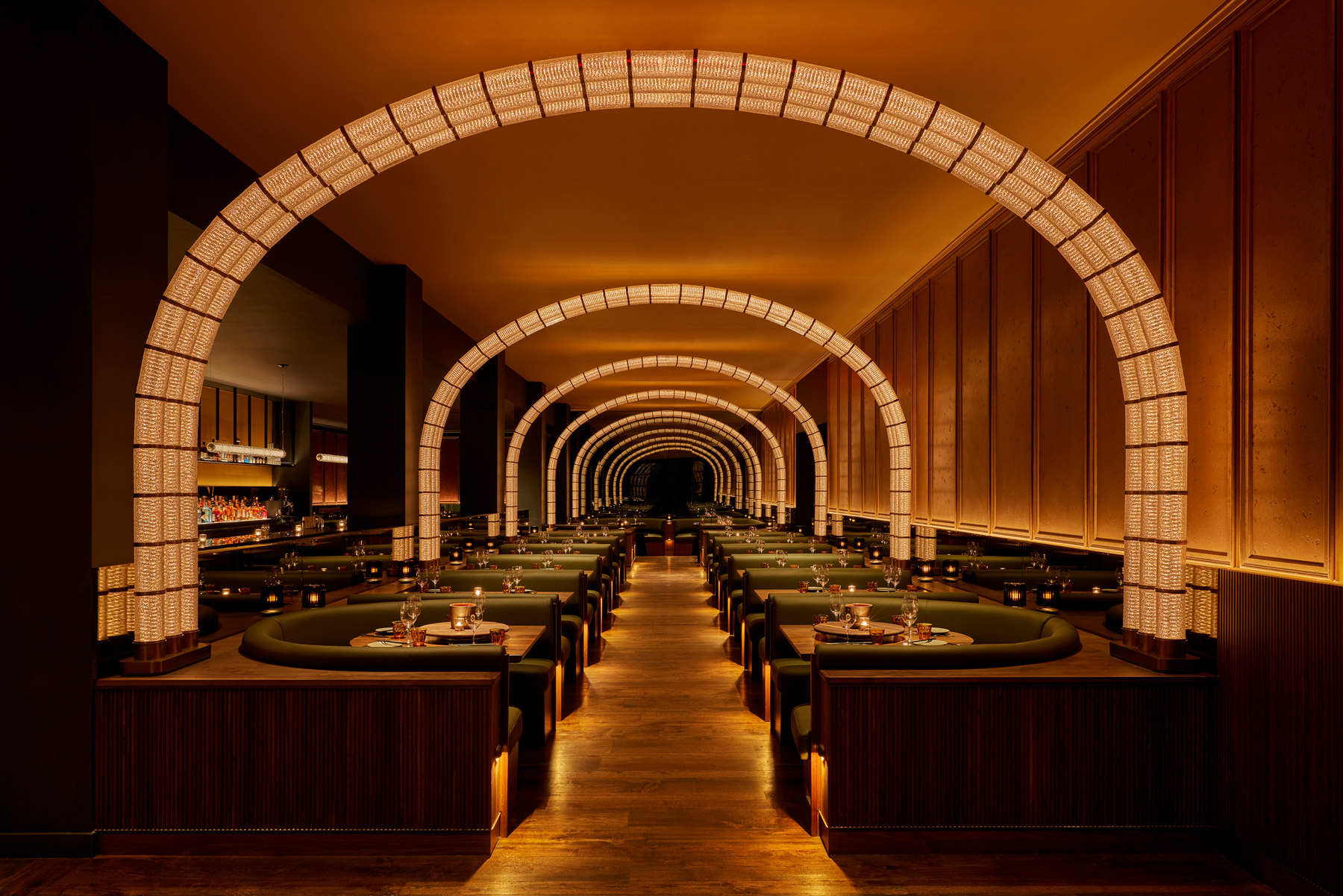 Stunning dining room with rows of tables and luxury arched lighting by Rockwell Group, interior designer for Viceroy FTL.