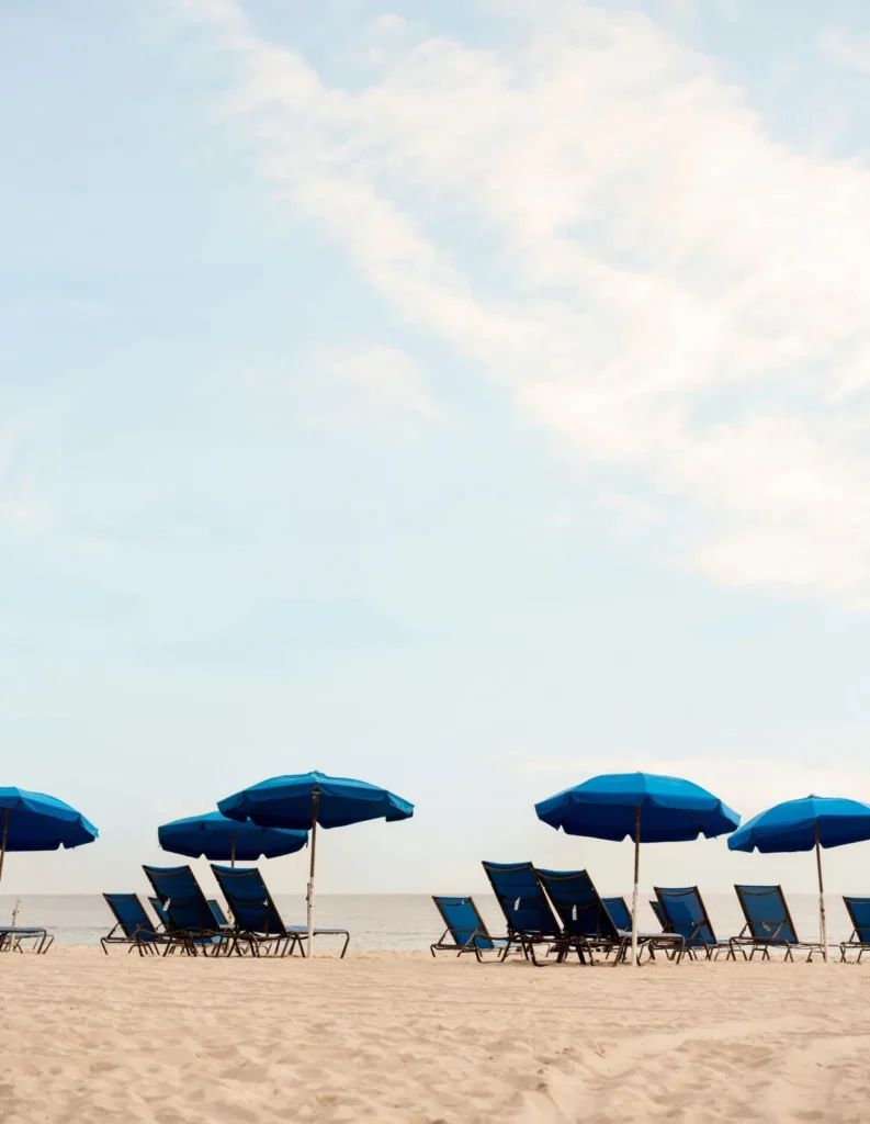 lounge chairs and umbrellas on beach overlooking ocean